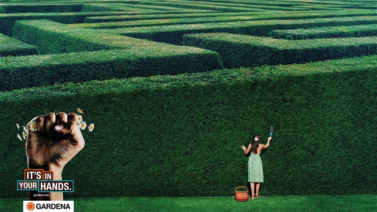 Advertising poster for Gardena gardening tools showing a woman trimming a labyrinth by hand